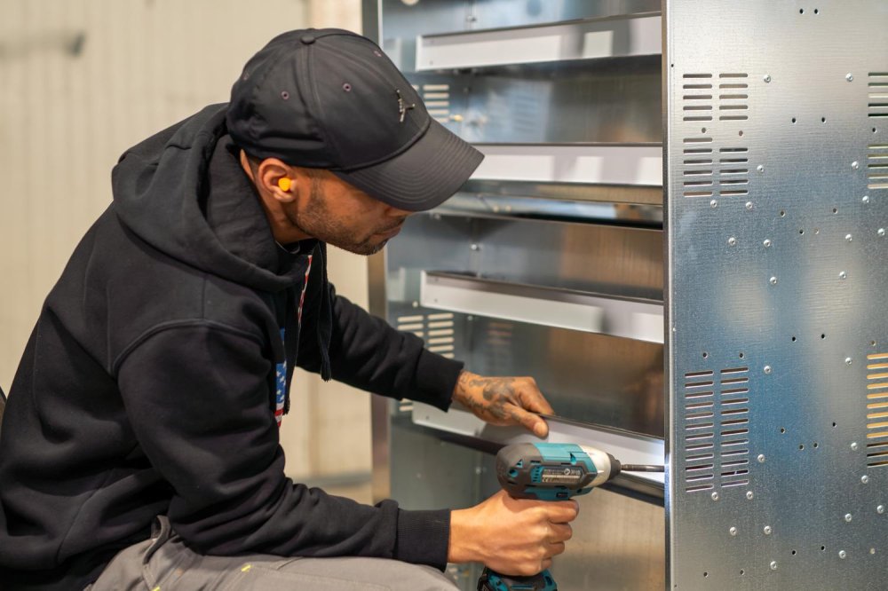Un lavoratore della cooperativa Il Calabrone al lavoro con un avvitatore nel reparto assemblaggi