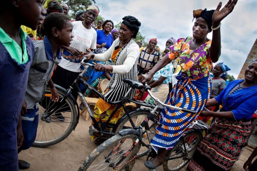Donna africana molto colorata con la bicicletta