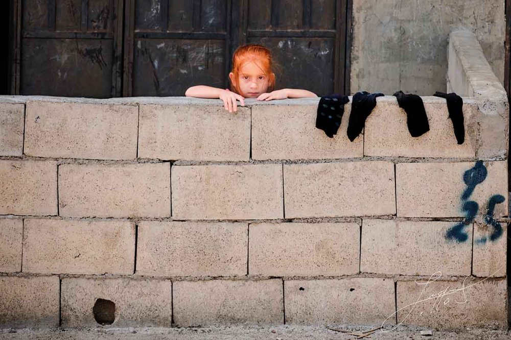 Bambina dietro al muretto ad Akkar