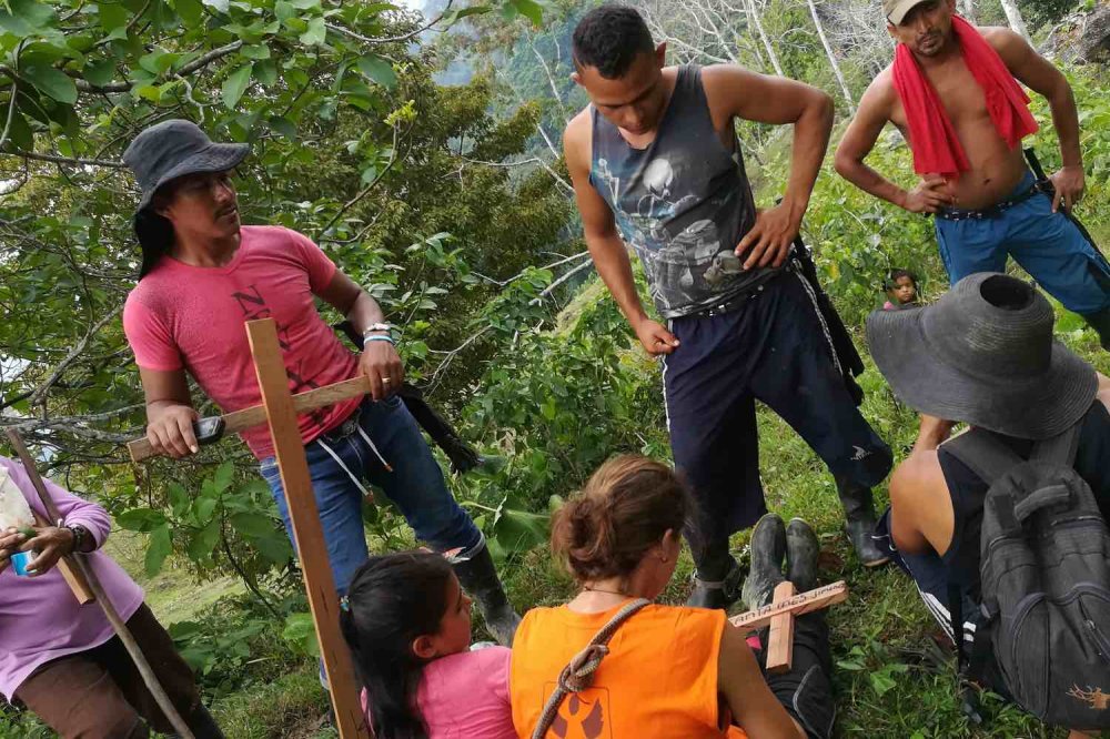 Volontari con contadini colombiani costruiscono croci di legno nella foresta