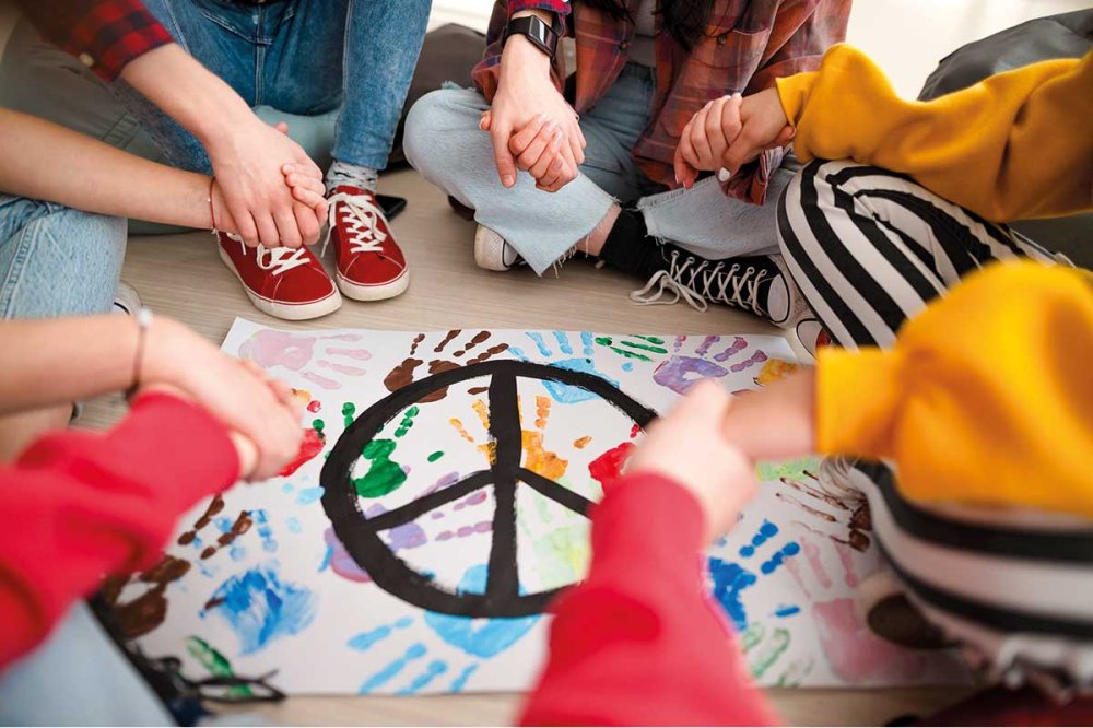 Cerchio di giovani intorno a un simbolo di pace