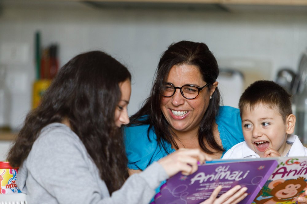 Mamma sorride leggendo libro ai bambini