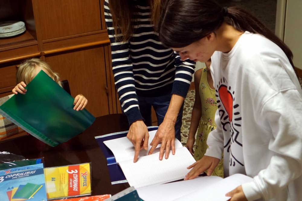 Volontari aiutano le mamme ucraine con i quaderni di scuola