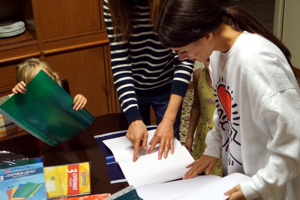 Volontari aiutano le mamme ucraine con i quaderni di scuola