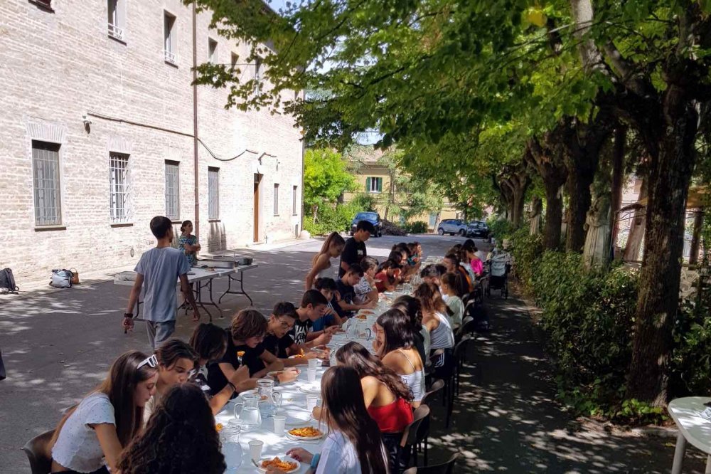 Tavolata con giovani nel cortile dell'ex convento