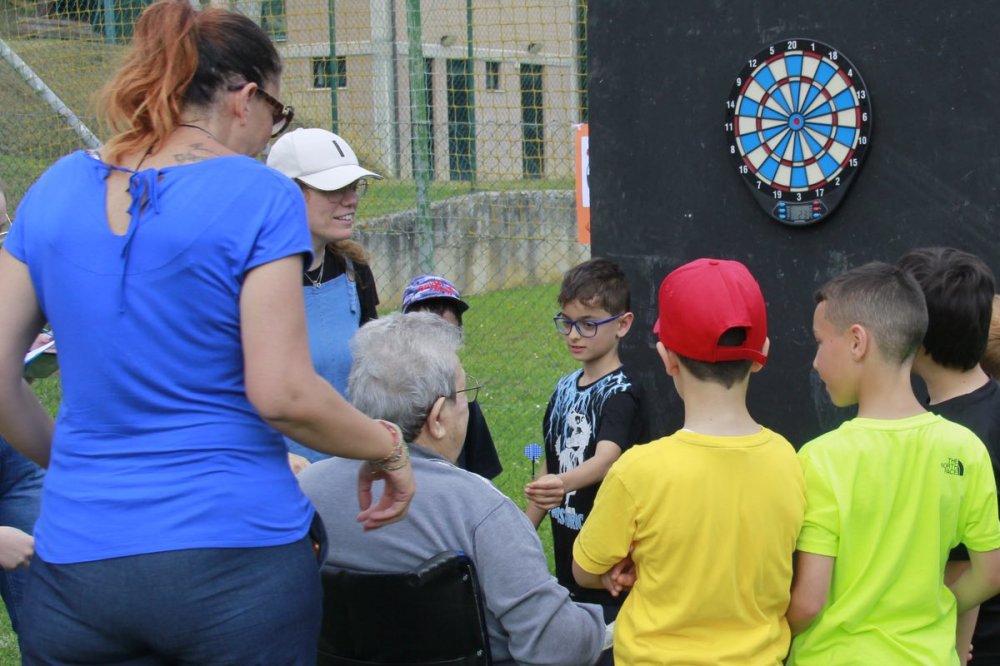 Persona disabile lancia freccette aiutata dai bambini