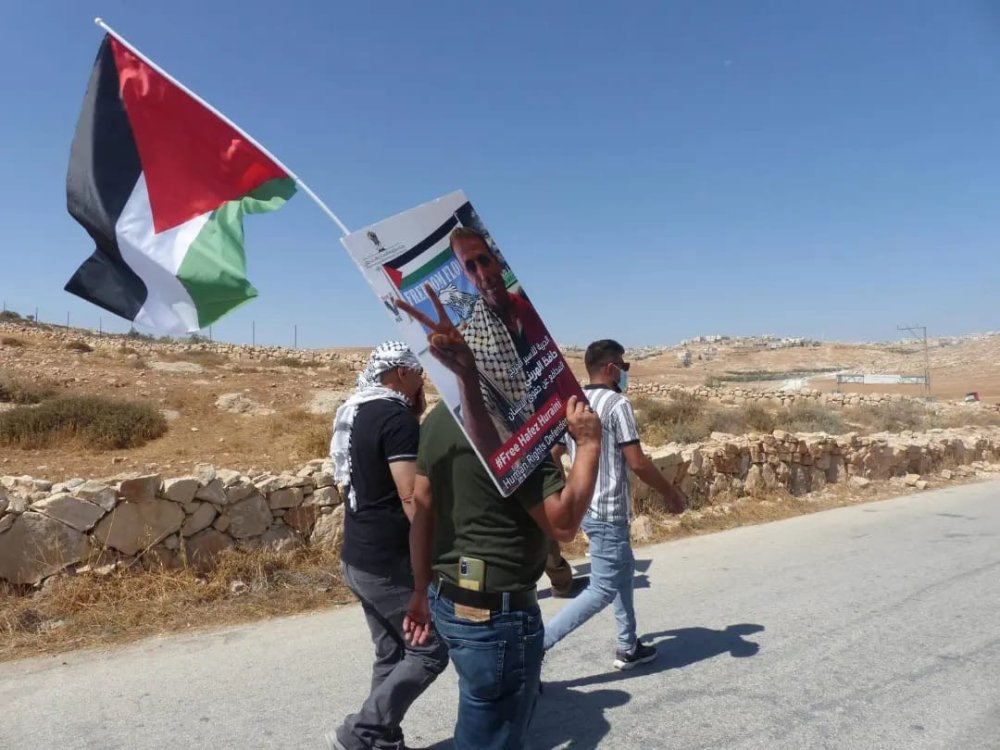 Manifestante palestinese con foto di Hafez Huraini 