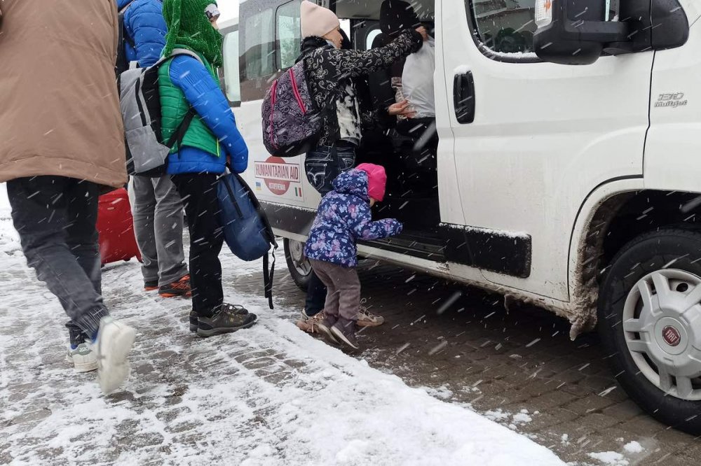 Una bambina si prepara a lasciare l'Ucraina sui furgoni