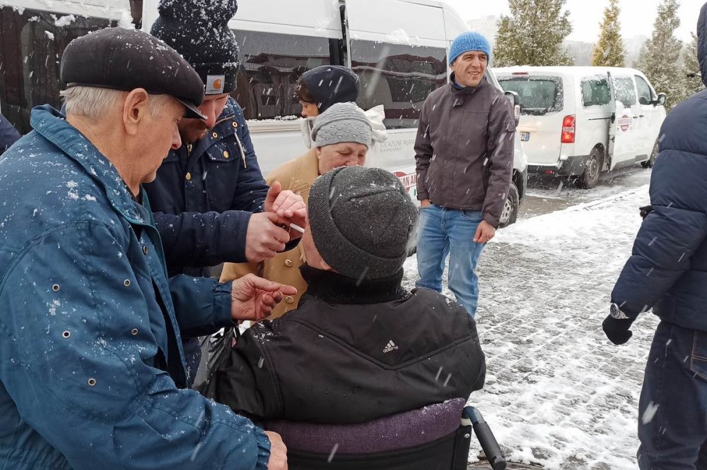 Persona disabile si prepara a lasciare l'Ucraina sui furgoni
