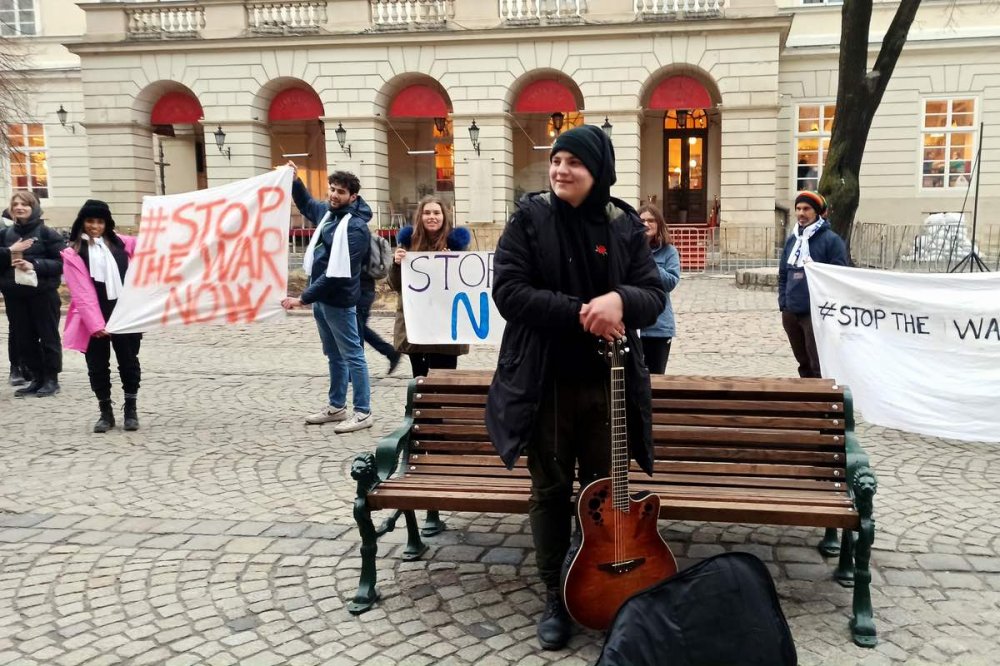 Donna guarda gli striscioni con la scritta #stopthewarnow