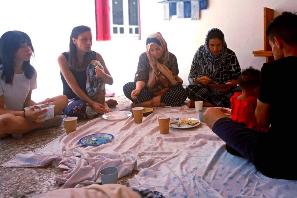 Famiglie di profughi durante il pranzo tipico