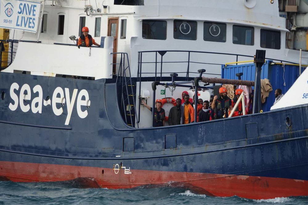 Esterne della Alan Kurdi con scritta Sea-Eye e profughi a bordo