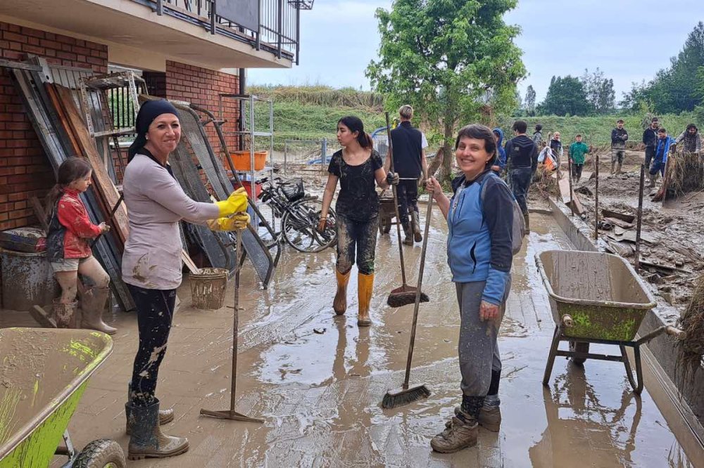 Volontari spalano il fango e sorridono